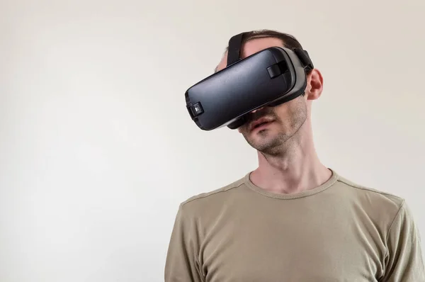 Homem explorando a realidade virtual de tecnologia moderna com exibição montada na cabeça no fundo branco — Fotografia de Stock