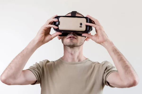 Homem explorando a realidade virtual de tecnologia moderna com exibição montada na cabeça no fundo branco — Fotografia de Stock