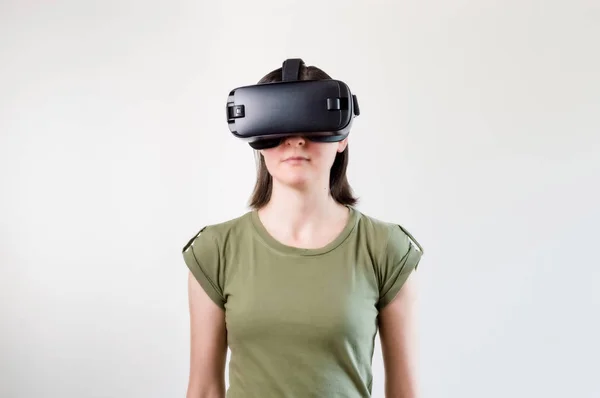 Mulher morena explorando a tecnologia moderna realidade virtual com cabeça montada exposição no fundo branco — Fotografia de Stock