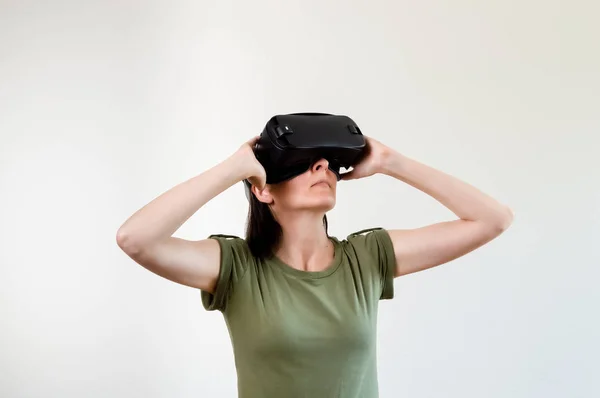 Mujer morena explorando la tecnología moderna realidad virtual con pantalla montada en la cabeza sobre fondo blanco —  Fotos de Stock