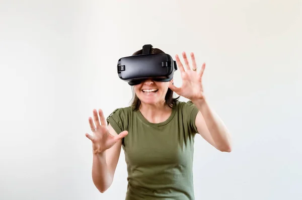 Mulher morena explorando a tecnologia moderna realidade virtual com cabeça montada exposição no fundo branco — Fotografia de Stock