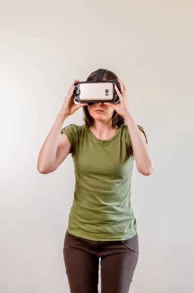 Mulher morena explorando a tecnologia moderna realidade virtual com cabeça montada exposição no fundo branco — Fotografia de Stock