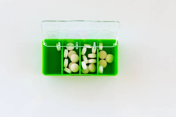 Белые медицинские таблетки в зеленой коробке с лекарствами. Вид сверху с пространством для копирования . — стоковое фото