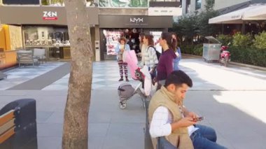 Beyaz kadın hafta sonu Bağdat Caddesi 'ndeki kafe ve dükkanların yakınında tek başına yürüyor.