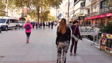 Beyaz kadın hafta sonu Bağdat Caddesi 'ndeki mağazaların yakınında tek başına yürüyor.