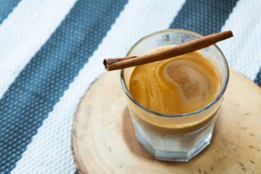 Tarçın ve ahşap masa örtüsü mavi model arka plan kopya alanı ile bar altlığı ile kahve cam