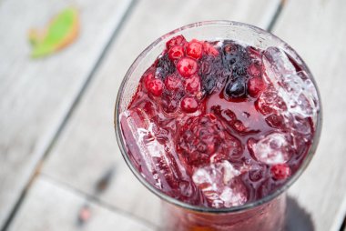 Suyu karışımı berry meyve içki kırmızı mor renk ahşap teras üzerinde uzun bardak