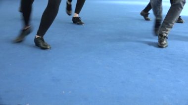 Dans dersleri, 50 'lerin yaşam tarzı, musluklar. Caz tarzı, tiyatroda sahne. Dansçının ayakları yakın. Mavi zeminde dans eden siyah step ayakkabıları, eski tarz, klasik müzik.