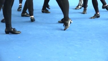 İnsanlar müzik festivalinde step dansı yapıyor. Tamponlar mavi kata çarpıyor. Tap ayakkabılar, halı arka planında parlak bir ışık. Klasik dans tarzı, boş zaman, müzik kültürü.