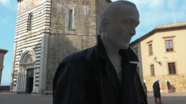 Volterra, Toskana, İtalya - Temmuz 2018 - San Giovanni 'nin antik vaftiz töreninin önünde geçici sanat kurulumu. Mankenlerle dolu eski ve güzel bir bina. Sanatsal proje ve turizm merkezi
