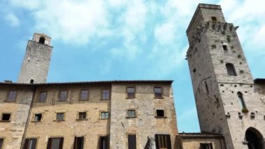 Ortaçağ bina ve kulelerinin panoramik manzarası, San Gimignano, Toskana, İtalya. Antik köyün ana meydanındaki tarihi mimarinin ayrıntıları. Tipik eski Toskana şehrinde İtalyan bayramı eğlencesi