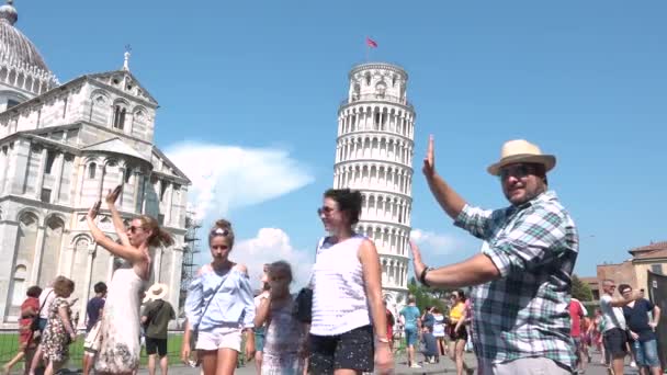 在意大利托斯卡纳 一个快乐的男人拿着比萨塔摆姿势很开心 展示斜塔的游客 带有滑稽的陈规定型图片 有趣的纪念品照片旅行 最佳地点和做的事情 — 图库视频影像