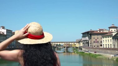 Ponte Vecchio, Florence, Tuscany, İtalya yakınlarında kalp sembolü yapan neşeli bir kadın. Eski köprü, aşk işareti, güzel bir eğlence ve turizm merkezi için sevgi gösteren mutlu bir gezgin.