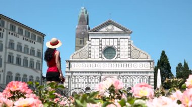 Female tourist taking picture of Santa Maria Novella church, Florence, Italy. Caucasian woman with camera traveling to Tuscany, things to do, photo holidays in Europe, sightseeing of Italian tour