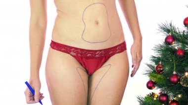 Beyaz kadın Noel 'den sonra şişmanlıyor ve karın, kalça ve kalçaların estetik liposuction ameliyatı için vücuduna estetik ameliyat çizgileri çiziyor. Vücut kontrolü, kilo kaybı ve selülit çıkarma kavramı