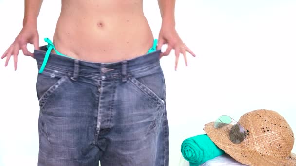 薄い女の子が大きすぎるパンツを見る 痩せた女性が痩身 食事をし ウエストラインを減少させます ビーチボディ準備ができてシリーズ 夏のために痩身 休日前の体重減少 夏の減量目標 — ストック動画