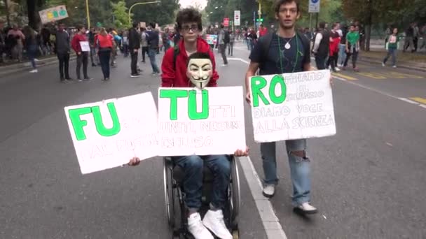 ミラノ イタリア 2019年9月27日気候変動のための世界的なストライキでデモを行う少年たち 男性活動家ピケットサインを持つ学生未来 緑のポスターで将来のための金曜日に若い障害のある学生 — ストック動画