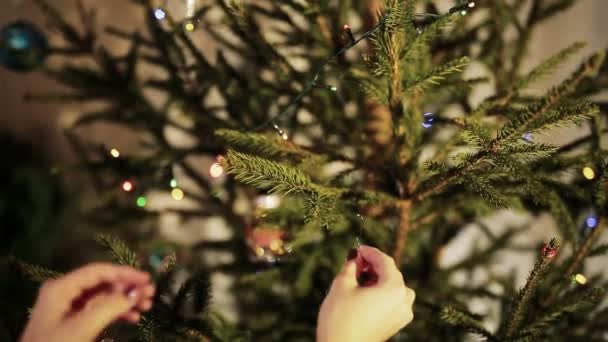 Las manos de la mujer decoran el árbol de Navidad de cerca — Vídeos de Stock