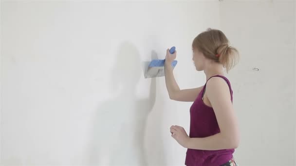 Kvindelige arbejdstager udjævning gips på væggen derhjemme – Stock-video