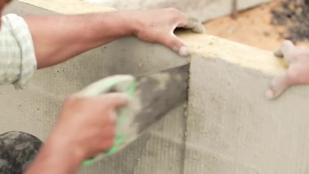 Worker measuring and cutting mineral wool — Stockvideo