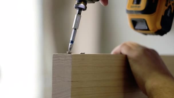 Man verzamelt meubels in een workshop. Mannelijke handen draai de schroef met een schroevendraaier — Stockvideo