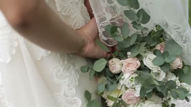 Sposa che tiene il bouquet alle sue spalle. Da vicino. — Video Stock