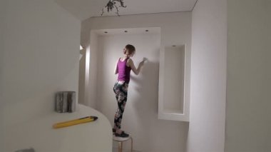 Spatulalı kadın müteahhit. Usta sıva duvarı.