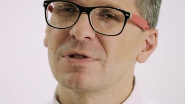 Duygusal ve jestçi bir adam evde şarkı söyler. Gözlüklü adam.