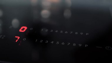 Adam elektrikli ocağın düğmesine basıyor.