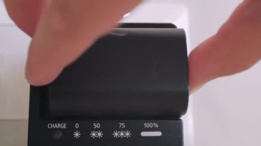 Adam siyah şarj aletine elle pil takıyor