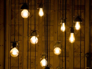 Ahşap arka planda parlayan klasik asma ampulleri