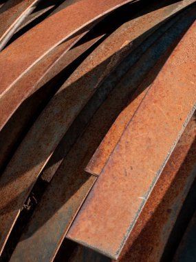Belirgin pas ve yıpranmış dokuları olan birkaç metal kirişin detaylı yakın plan fotoğrafı. Üst üste binen açılar ve turuncu kahverengi renkler eski endüstriyel maddeleri vurguluyor ve bu görüntü endüstriyel ve dokular için ideal hale geliyor.