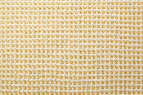 Background of crocheted wool thread of yellow color.