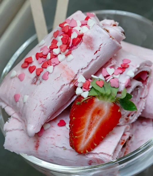 Roll ice cream is made by hand on the freezer. Sweet dessert made from natural strawberries and ingredients.