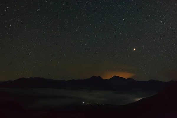 Bright stars  in the night sky. Foggy mist over the highlands. North Caucasus in Russia.