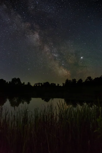 Stars in the sky at night. Bright milky way over the lake.