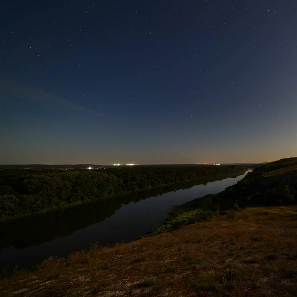 Stars in the night sky over the river. Illuminated by moonlight.