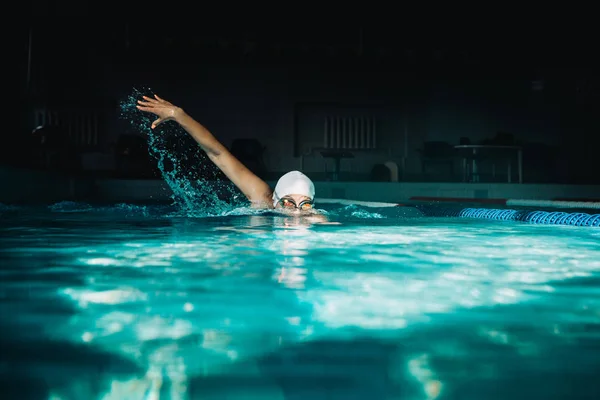 Woman swims freestyle in the pool