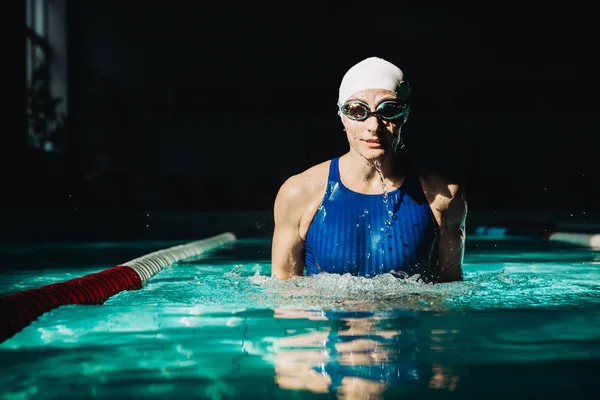 Nadador profesional, salpicaduras de agua, gafas y gorra de natación — Foto de Stock