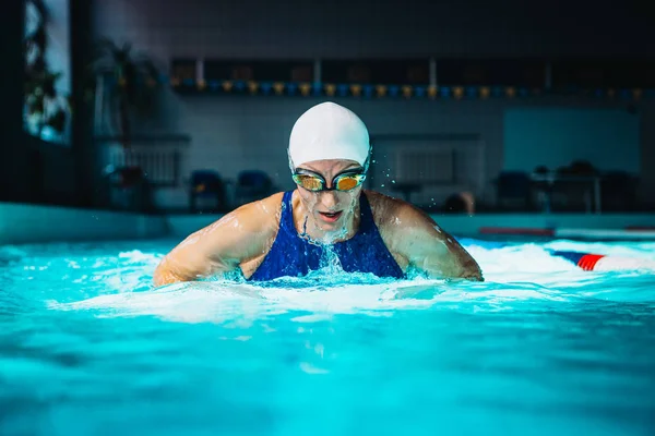 Professionele vrouw zwemmer zwemmen met behulp van de schoolslag techniek op — Stockfoto