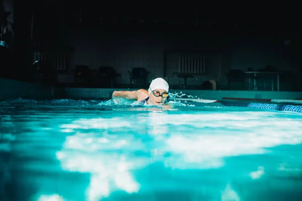 Professionele vrouw zwemmer zwemmen met behulp van de schoolslag techniek op — Stockfoto
