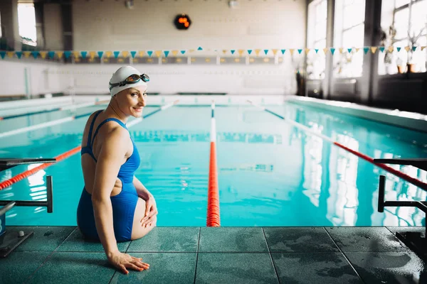 Bella nuotatrice femminile sul bordo della piscina — Foto Stock