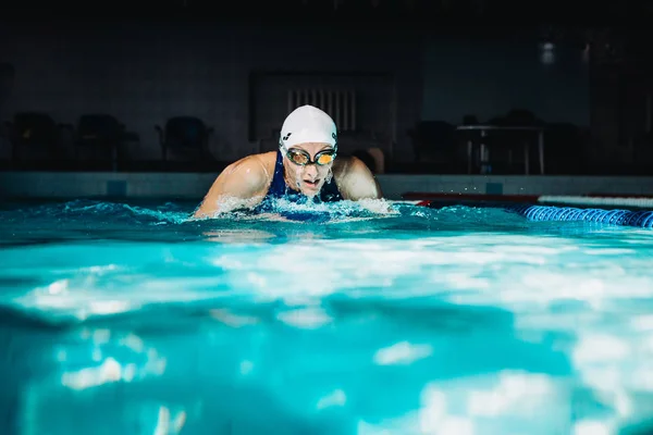 Professionele vrouw zwemmer zwemmen met behulp van de schoolslag techniek op — Stockfoto