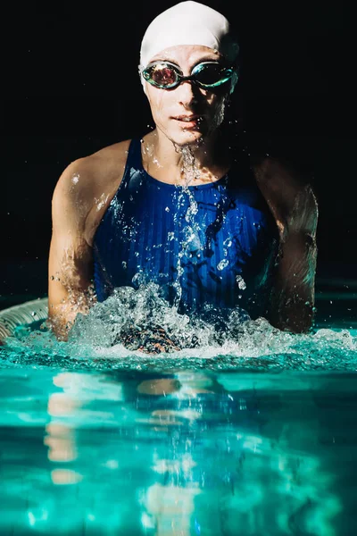 Профессиональный пловец, брызги воды, очки и плавательная шапочка — стоковое фото