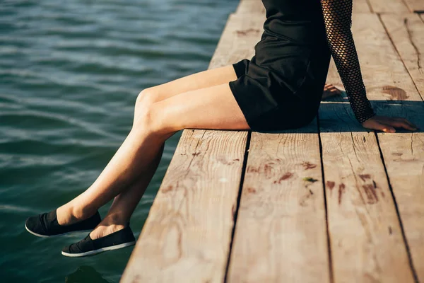 Ensam flicka sitter på bryggan på sommaren — Stockfoto