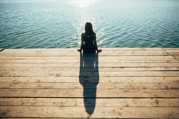 Menina solitária sentada no cais no verão — Fotografia de Stock