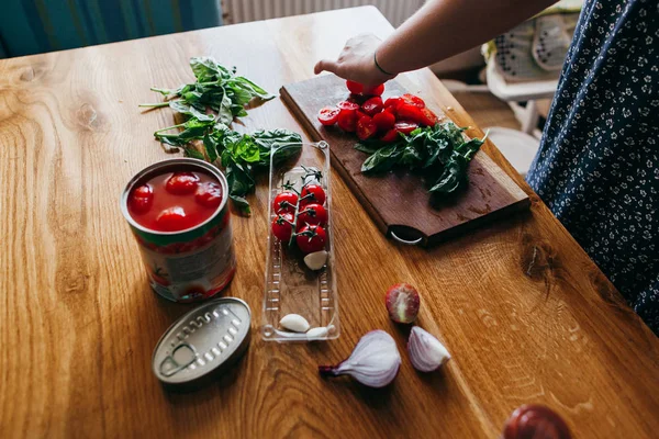 Woman cutting fresh vegetables on the kitchen table — Stock Photo, Image