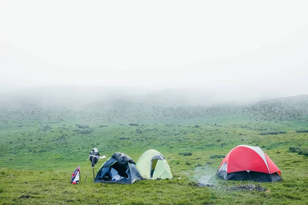 Algumas tendas de acampamento nas montanhas em um dia nebuloso — Fotografia de Stock