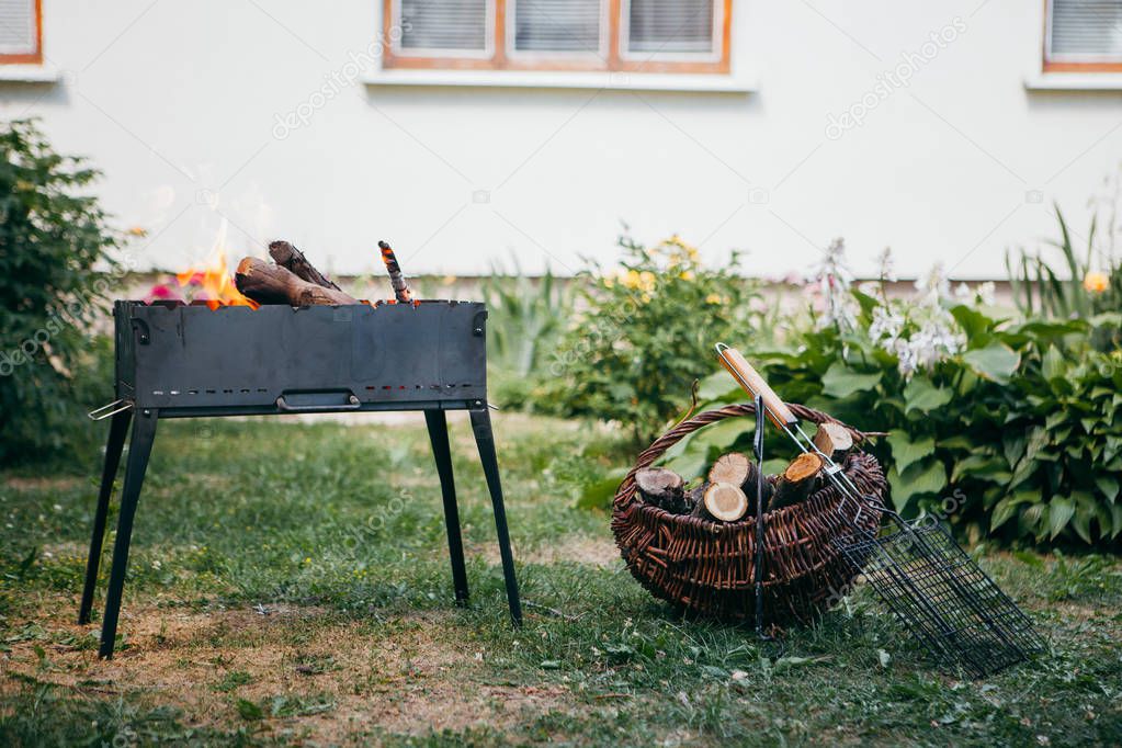 Flaming barbecue grill in the yard in summertime 