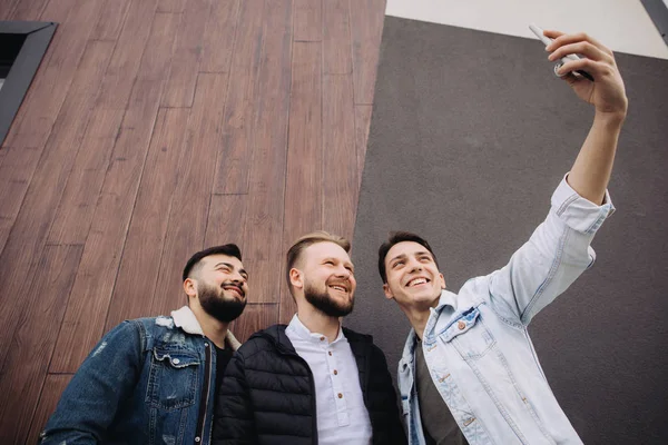 Happy friends taking a selfie next to the wall — Stock Photo, Image